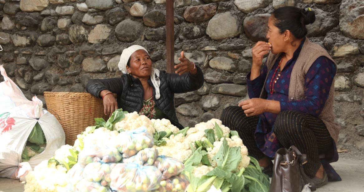 Women sell vegetables at a local community market